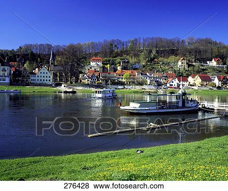 Stock Photo - Motorboats in water with a town in the background, Elbe River, Saxon, Switzerland . Fotosearch