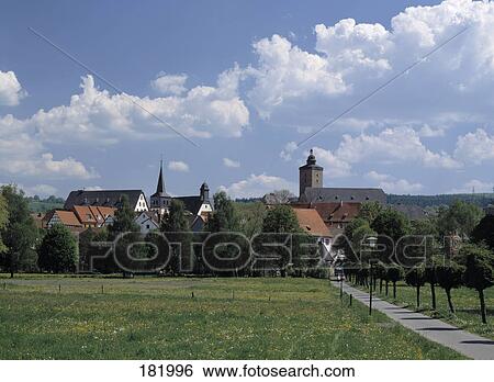 Stock Photograph - Path leading to village on landscape, Hesse, Germany . Fotosearch