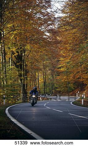Person riding motorbike on road, Odenwald Forest, Germany View Large Photo Image Stock Photo - Person riding motorbike on road, Odenwald Forest, Germany . Fotosearch