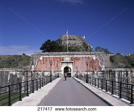 Person walking on bridge leading to archway of castle View Large Photo Image Stock Photo - Person walking on bridge leading to archway of castle . Fotosearch