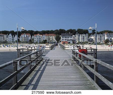 Stock Image - Pier over sea with tourist resort at background, Mecklenburg-Vorpommern, Germany . Fotosearch