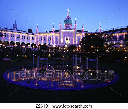 Stock Image - Pond in front of lit up palace at amusement park, Tivoli Gardens, Copenhagen, Denmark . Fotosearch