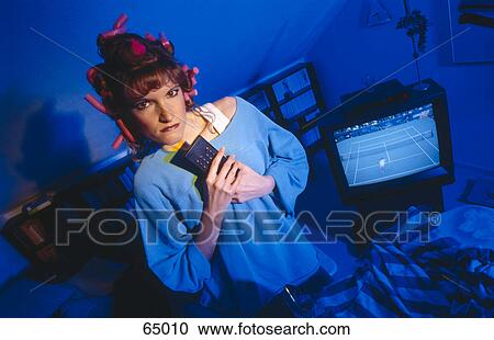 Portrait of a woman holding a remote control and looking angry View Large Photo Image Stock Image - Portrait of a woman holding a remote control and looking angry . Fotosearch