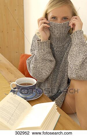 Portrait of mid adult woman hiding her face with pullover View Large Photo Image Stock Image - Portrait of mid adult woman hiding her face with pullover . Fotosearch