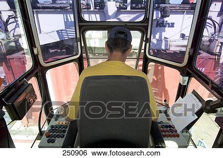 Rear view of man operating crane, Duisburg, Ruhr Basin, North Rhine-Westphalia, Germany View Large Photo Image Stock Photograph - Rear view of man operating crane, Duisburg, Ruhr Basin, North Rhine-Westphalia, Germany . Fotosearch