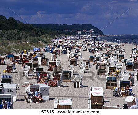 Stock Photography - Roofed wicker beach chairs and tourists on beach, Mecklenburg-Vorpommern, Germany . Fotosearch