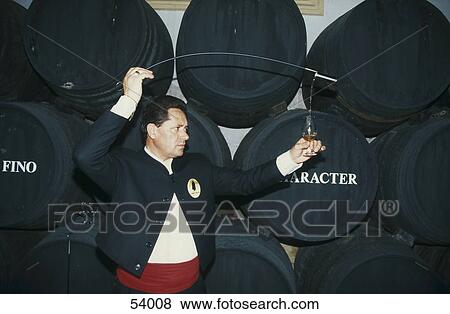 Stock Photo - Sherry tester pouring wine in glass, Jerez, Andalucia, Spain . Fotosearch