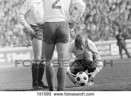 Stock Image - Soccer player placing soccer ball for free kick during match . Fotosearch