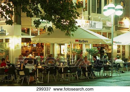 Stock Photo - Tourists enjoying at sidewalk cafe, Hannover, Lower Saxony, Germany . Fotosearch