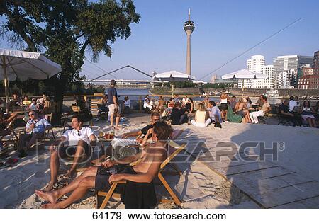 Stock Photo - Tourists relaxing on beach, Rheinturm Dusseldorf, Duesseldorf, North Rhine-Westphalia, Germany . Fotosearch