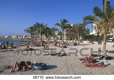 Stock Image - Tourists relaxing on the beach . Fotosearch