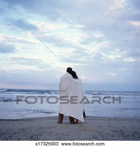 Couple Emballé Dans Couverture Sur Plage Coucher Soleil Vue Postérieure Banque Dimage