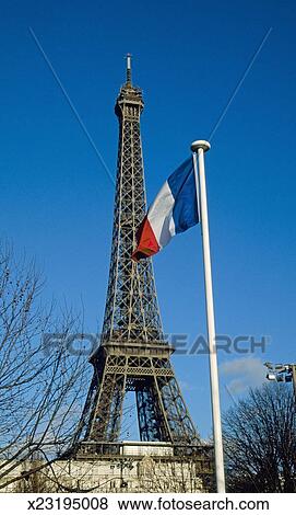 France, Paris, Eiffel tower with French flag, low angle ...