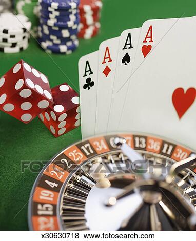 Roulette wheel, dice, playing cards and gambling chips, close-up Stock