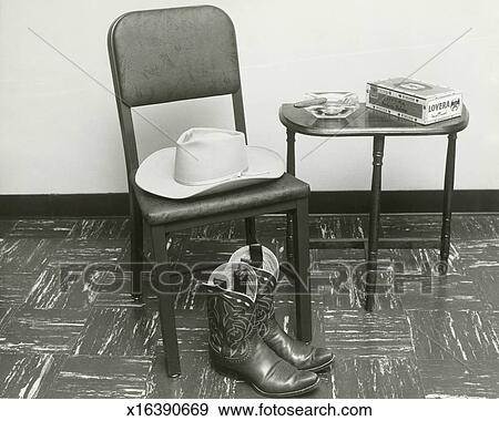 Cowboy Hat And Boots On Chair Beside Table Stock Photo X16390669