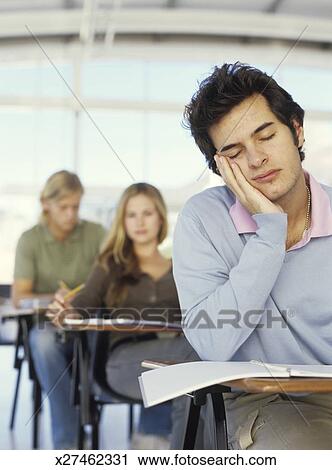 Young Man Asleep At Desk In Classroom Stock Image X27462331