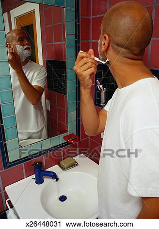 Man Shaving At A Bathroom Sink Stock Image