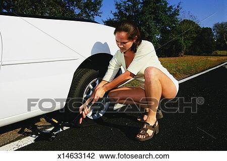 Woman changing flat tire Stock Image | x14633142 | Fotosearch