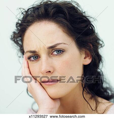Front View Portrait Of Young Woman With Hand Touching Her Face Stock Photo