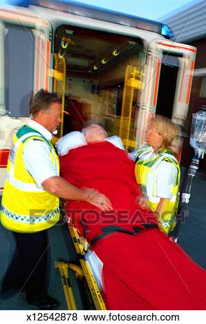 Ambulance personnel carrying a patient on a stretcher Stock Photo
