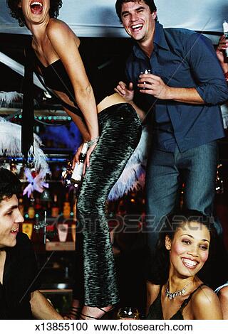 Side Profile Of A Couple Dancing On A Nightclub Bar Top Stock