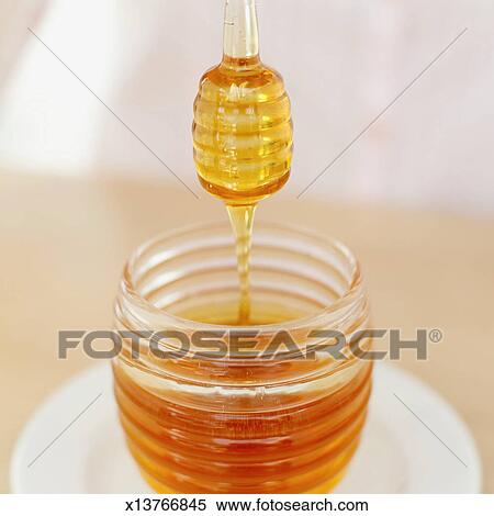 Download Close-up of a honey dipper over a jar of honey Stock ... Yellowimages Mockups