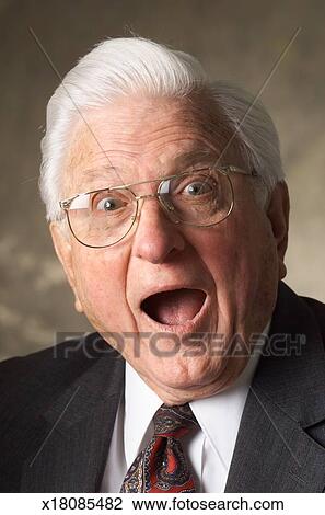 White Haired Elderly Caucasian Man In Suit Wears Glasses Stares
