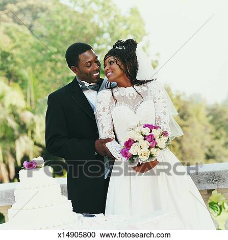 Young Newlywed Couple Standing On A Balcony At Their Wedding