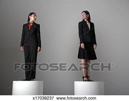 Two Women On Pedestals Looking At Each Other Stock Photo