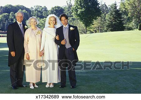 Bride And Groom With Mother And Father Posing At Outdoor Wedding