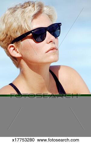 Woman With Short Hair By Pool Wearing Sunglasses Stock Image