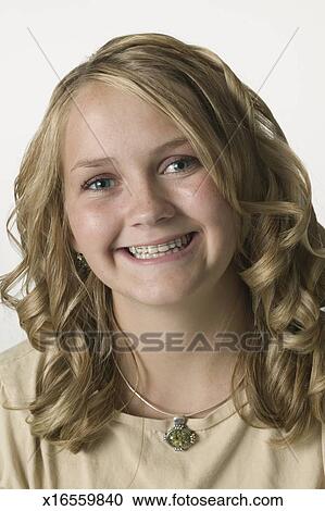 Young Smiling Girl With Blonde Curly Hair And Braces Portrait
