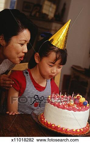 Girl 6 7 Blowing Out Candles On Birthday Cake In Living Room
