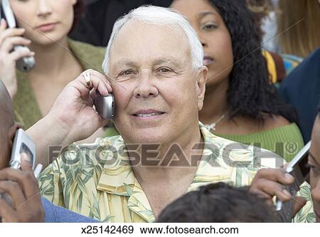 Focus On A White Haired Man In A Large Crowd Using Mobile Phones