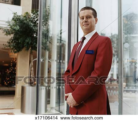 Portrait Of A Hotel Doorman In A Smart Red Jacket Standing In A