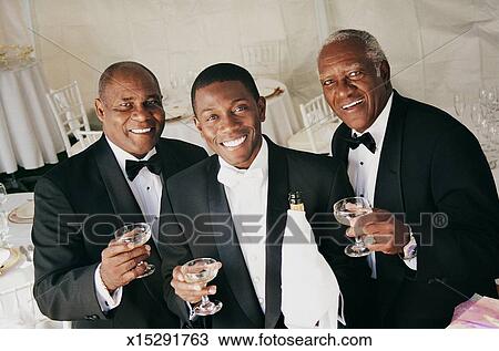 Three Men Drink A Toast Indoors At A Wedding Reception Stock Image