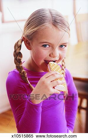 Stock Image of Girl with Pigtails Eating Ice Cream with a Hand on her