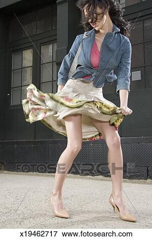 Picture of Woman outdoors on pavement, skirt blowing in 