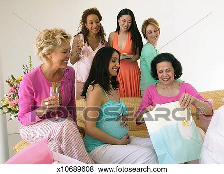 Group Of Women At Baby Shower Mature Woman Opening Gift Bag