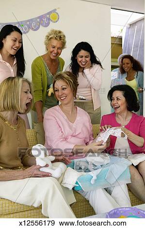 Group Of Women Gathered Around Sofa At Baby Shower Smiling Stock