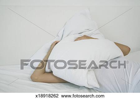 Young Woman Lying On Bed Head Under Pillow Stock Image