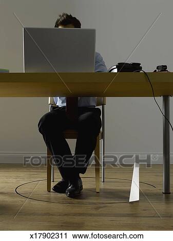 Man Using Laptop On Table Saw Cutting Wooden Floor Around Chair