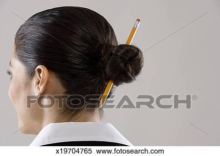 Young Woman With Pencil In Hair Bun Rear View Stock Photography