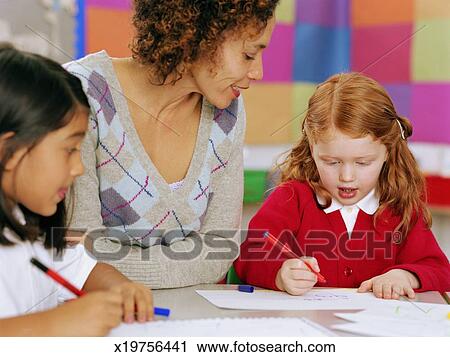Teacher Sitting At Table Watching Schoolgirl 5 7 Writing Teacher Sitting At Table Watching Schoolgirl 5 7 Writing