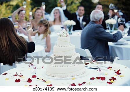 Guests Raising Toast At Wedding Reception Focus On Wedding Cake