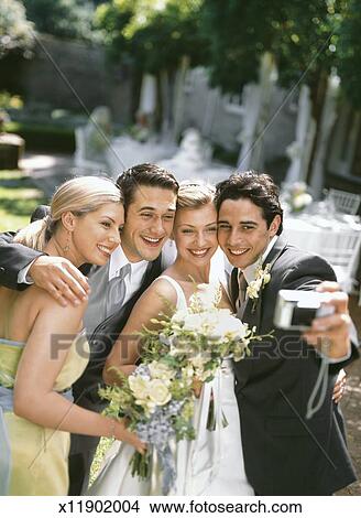 Stock Photo of Bride, groom, best man and bridesmaid photographing ...