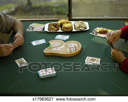 Senior Man And Woman Playing Cribbage Focus On Cribbage Board