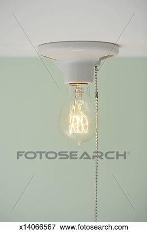 Light Bulb With Pull Cord Hanging From Ceiling Stock Photo