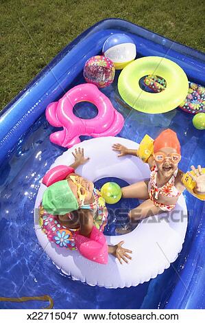 Two Sisters 3 4 On Inflatable Ring In Backyard Swimming Pool