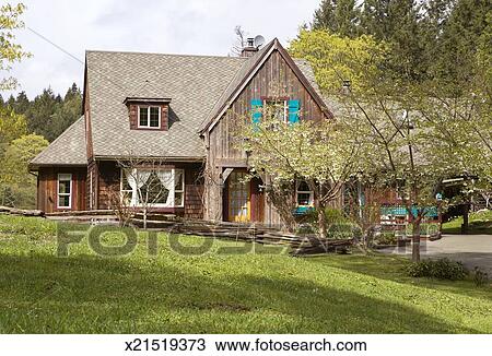 Exterior Of Old Fashioned Barn Style Home And Front Garden Stock